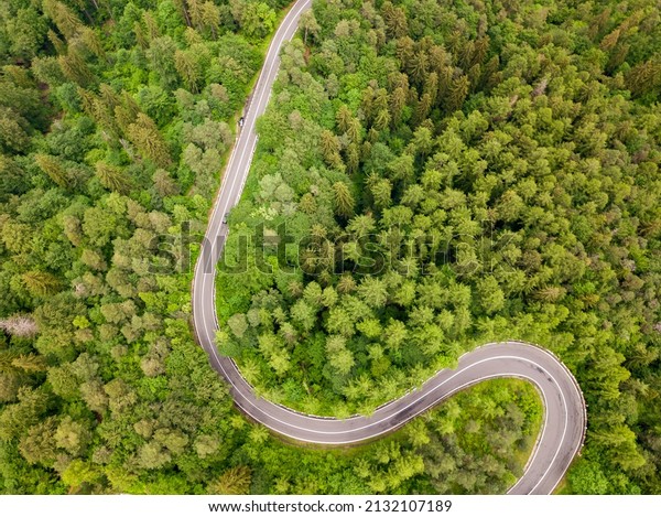Winding road from high mountain pass, in summer\
time. Aerial view by drone .\
Romania