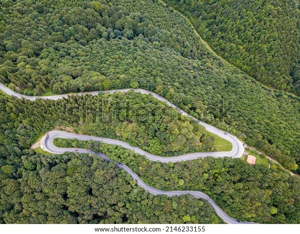 Winding road from high mountain pass, in summer\
time. Aerial view by drone.\
Romania
