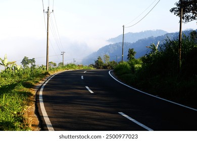 winding road in the mountains, with natural scenery background, sunlight, misty hills - Powered by Shutterstock