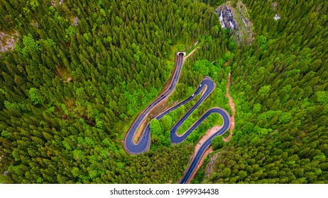 Winding road in the mountains, shot from a drone from a higher altitude and a low camera angle. Photography of a serpentine road in the mountains.