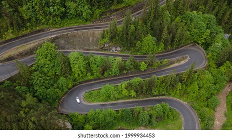 Winding Road In The Mountains, Shot From A Drone From A Lower Altitude And A Low Camera Angle. Photography Of A Serpentine Road In The Mountains.