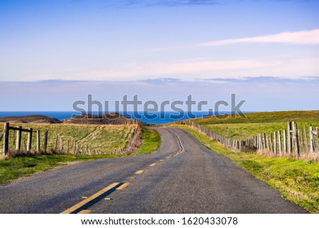 Winding road on the Pacific Ocean coastline on a clear sunny day, Point Reyes National Seashore, California