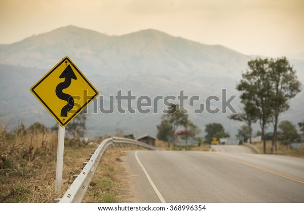 Winding Road Sign on asphalt
road
