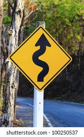 Winding Road Sign In Yellow And Black