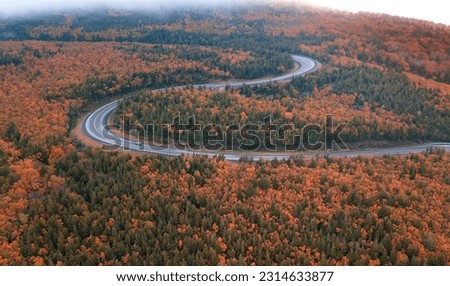 Winding roads of the world famous Cabot Trail, Cape Breton Highlands in the peak autumn fall season with mixed color deciduous trees.