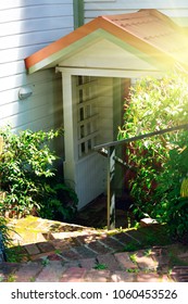 Winding stone steps leading down to the red-roof wooden porch. Concept of shelter, house, and returning home. Selective focus.