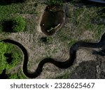 winding stream with ponds. people renewed the zigzagging cancel melioration, measures to maintain water in the landscape. a pond with a drowned tree is surrounded by lying frozen grass like fur