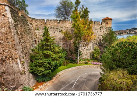 Winding street below stone wall of the Citadelle Saint-Elme in Villefranche sur Mer in France, citadel from 16th century on French Riviera