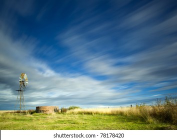 windmill in field with motion in the clouds