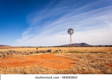 A windmill in a field in the South Australian outback. This windmill stands upon red dirt in the outback between the Flinders Ranges National Park and the state capital, Adelaide.