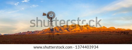 A windmill with the Flinders Ranges behind it in the Australian outback. Flinders Ranges National Park, South Australia, Australia.
