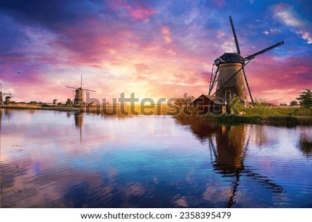 Windmill in Holland Michigan - An authentic wooden windmill from the Netherlands rises behind a field of tulips in Holland Michigan at Springtime. High quality photo