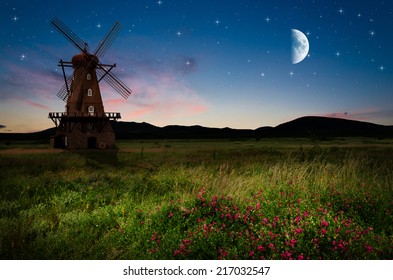 Windmill in the night. Elements of this image furnished by NASA.