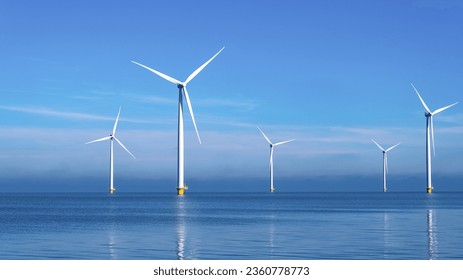 Windmill park with clouds and a blue sky, wind mill turbines in the ocean aerial view of a wind farm in the Nehterlands production clean energy