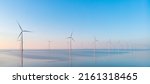 Windmill park in the ocean, drone aerial view of windmill turbines generating green energy electric, windmills isolated at sea in the Netherlands. High quality 4k footage