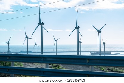 Windmill Park With Stormy Clouds And A Clear Blue Sky, Horizon Over Water. Ocean Of Canary Islands