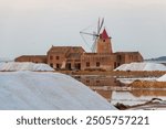 windmill and piles of white salt in the famous salt mines of Marsala.