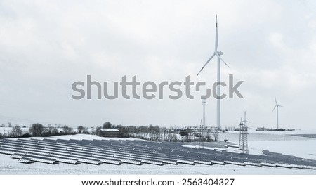 Windmill with solar panel in snow, dark doldrums or wind lull in winter, no renewable sustainable energy, environmental conversation