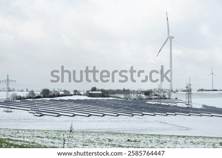 Windmill with solar panel in snow, dark doldrums or wind lull in winter, no renewable sustainable energy, environmental conversation
