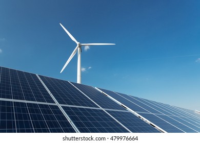 Windmill And Solar Panels On Blue Sky At Daytime