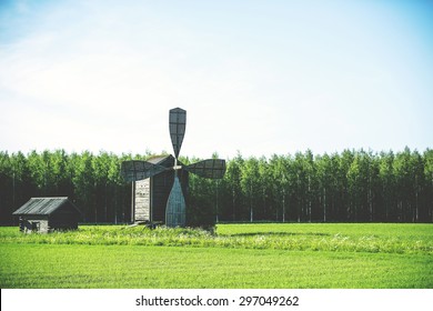 Windmill standing in alone in the field. Image has a vintage effect.