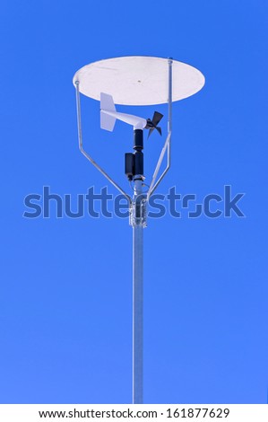 Windmill style anemometer with a canopy on blue sky