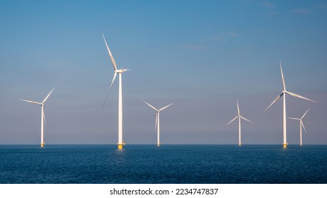 Windmill turbines in the Netherlands at sea with a blue sky - Shutterstock ID 2234747837