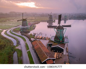 Windmill village Zaanse Schans, historical green wooden house at the windmill village zaanse schans Netherlands. Drone view from above during sunrise with misty foggy weather