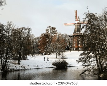 The Windmill of Wallwnlagen Park, Bremen, Germany, in a snow covered winter landscape - Shutterstock ID 2394049653