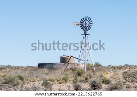 A windmill, with a watertank inside an old corrugated iron dam, on the road between Loxton and Fraserburg in the Northern Cape Karoo