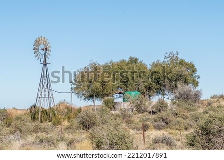 A windmill and a watertank inside an old reservoir on the road between Loxton and Fraserburg in the Northern Cape Karoo