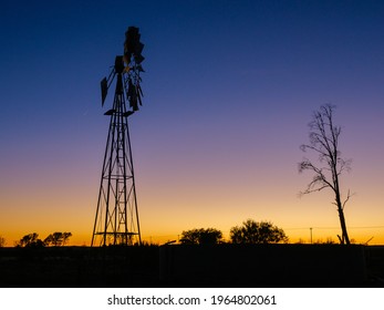 A windmill (windpump) against a beautiful dawn sky at the tiny Karoo town of Freserburg. Northern Cape. South Africa.