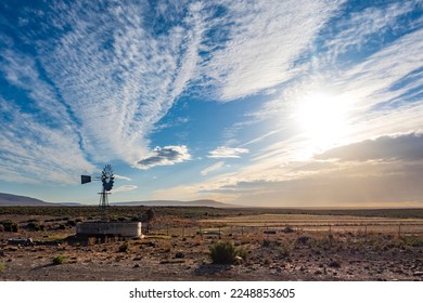 Windmill (windpump) in a Roggeveld rural scene showing beautiful cloud formations. Near Sutherland, Northern Cape. South Africa.