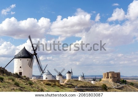 Windmills with a castle in the background. The image recalls the novel Don Quixote de La Mancha ... Consuegra, Castilla La Mancha. Spain.