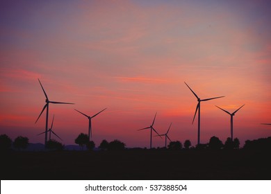 Windmills For Electric Power On Sunset Sky Background