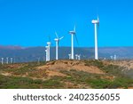 Windmills for electric power production . Giant wind turbines are  placed on the ridges, harnessing the power of the wind