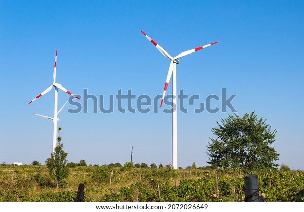 Windmills for electricity generation. Green energy
concept. Background with copy space for text. Modern farm outside
the city.