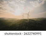 Windmills on green ridges under beautiful heavy clouds