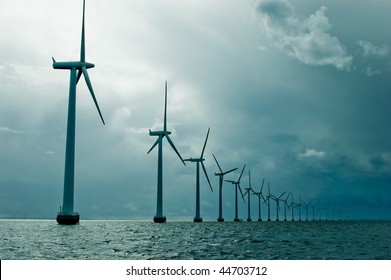 Windmills in a row on cloudy weather