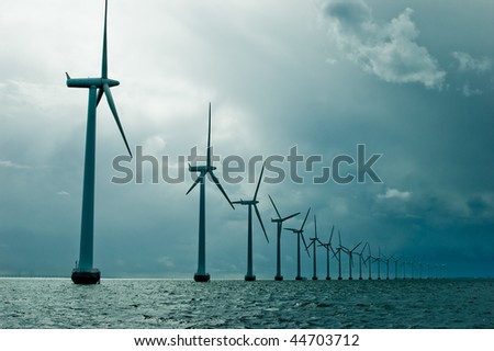 Windmills in a row on cloudy weather