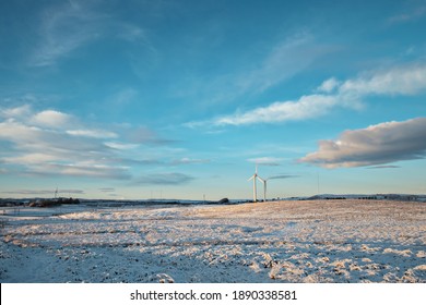 Windmills In A Snow Field And Sky In Winter. West Lothian, Scotland, UK