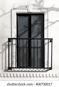 Window with balcony and shades of tree branches