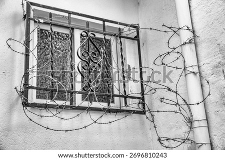 window with bars and barbed wire