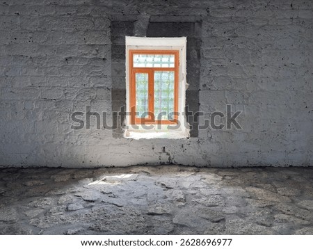 window with bars in old white brick wall