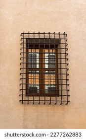 Window with bars on the side of a building.