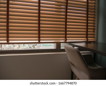 Window Blinds curtain in room , Chair and table in room .