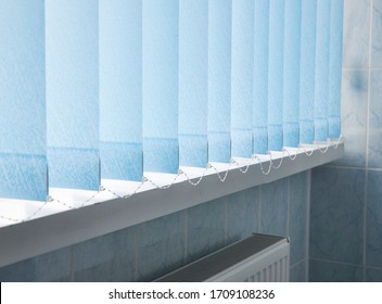 Window blue cotton blinds, vertical louvers, swings is a good window covering in offices.
