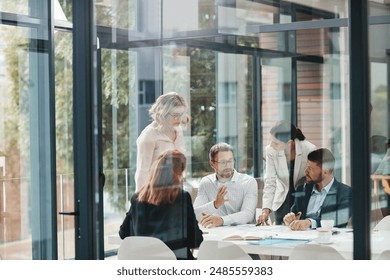 Window, business people or planning in meeting for paperwork, teamwork or collaboration together. Shareholders, investor or executive director speaking in discussion for feedback, review or project - Powered by Shutterstock