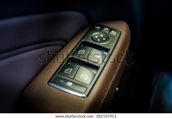 window buttons leather upholstery.Detail\
on some buttons on a car\'s steering wheel\
