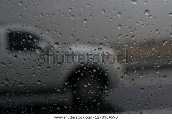 window
of the car during rainy day with water eye
drops